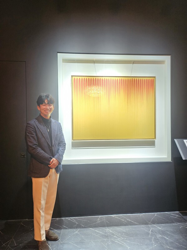 이우환 작가의 작품 "선으로부터"를 설명하고 있는 원준섭 대표.